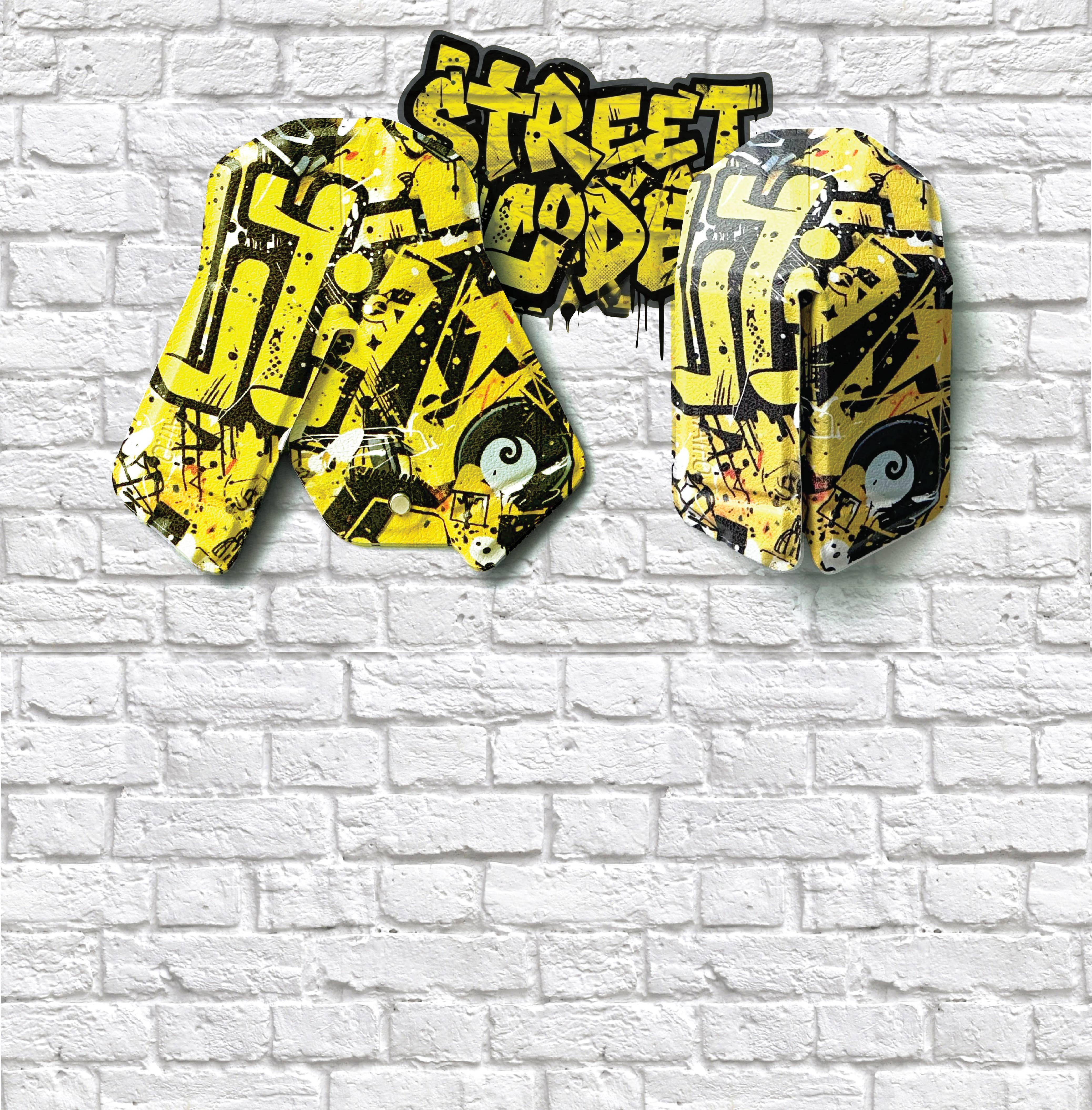 Yellow and black 'Street Code' graffiti-style text on a white brick wall.